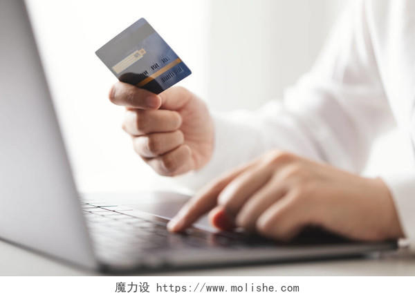 持信用卡和使用笔记本电脑的人在家里工作的女商人在网上购物